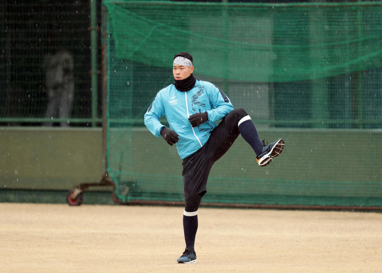 みぞれが降る中、ウオーミングアップする阪神佐藤輝（撮影・前田充）