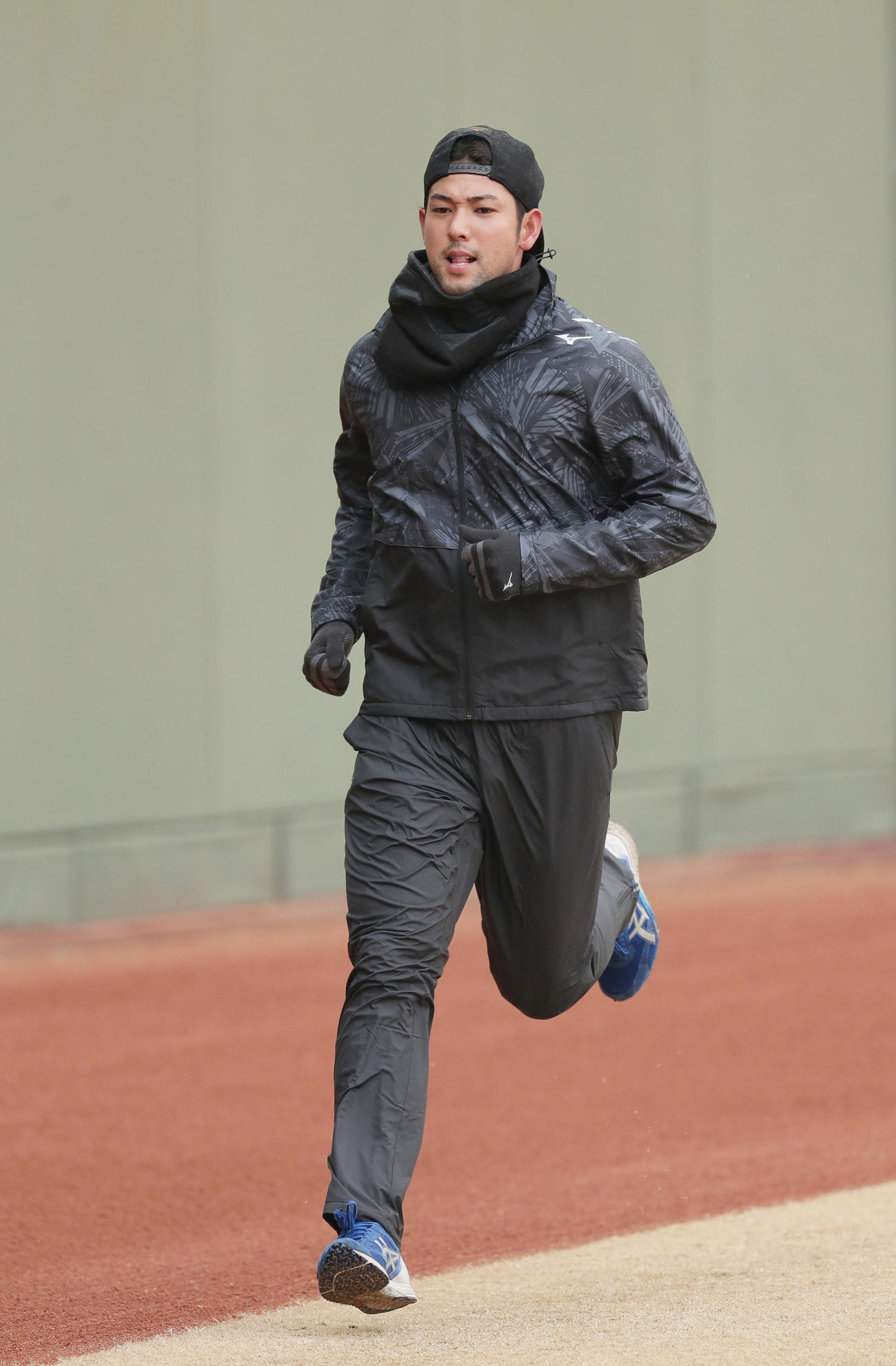 グラウンドに一番乗りで現れ、外野をランニングする阪神加治屋（撮影・前田充）