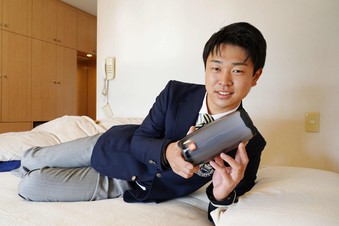 入寮した中日高橋宏は、同級生らから贈られたスピーカーを手にエアウィーヴの上で横になる（球団提供）