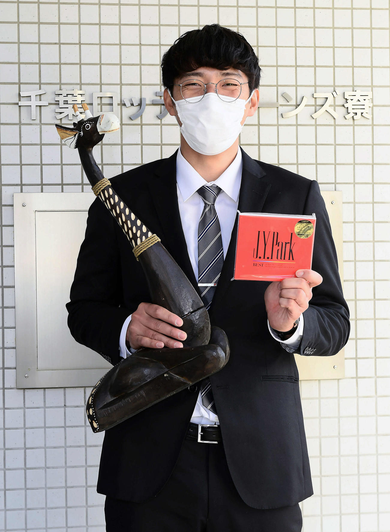 持参したキリンの置物とJ.Y.ParkのCDを手にするドラフト4位の河村（代表撮影）