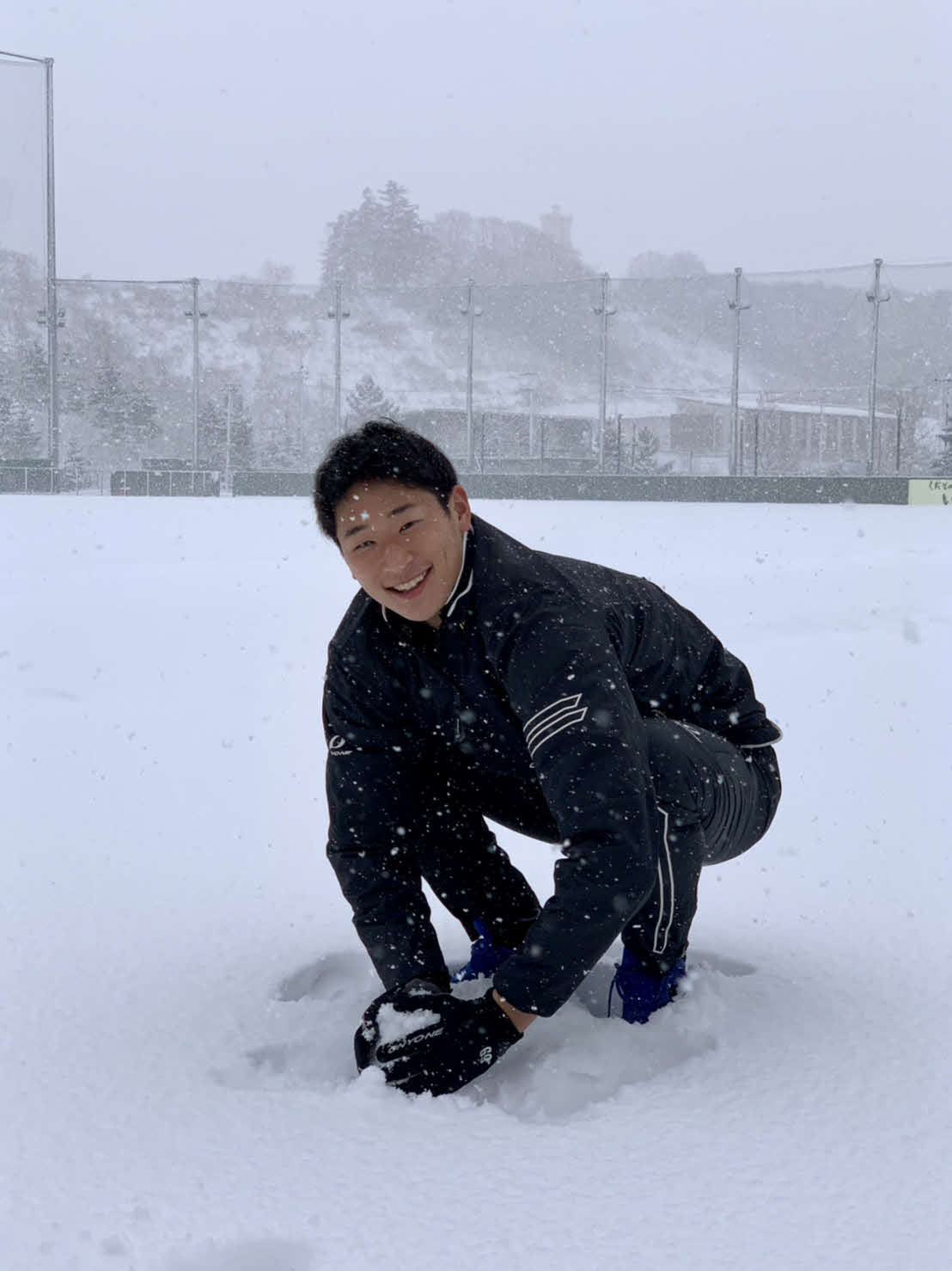 グラウンドに積もった雪を集める楽天ドラフト6位の内（球団提供）