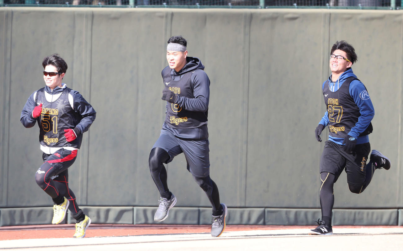 阪神新人合同自主トレで、伊藤将（右）、中野（左）とダッシュする佐藤輝（代表撮影）