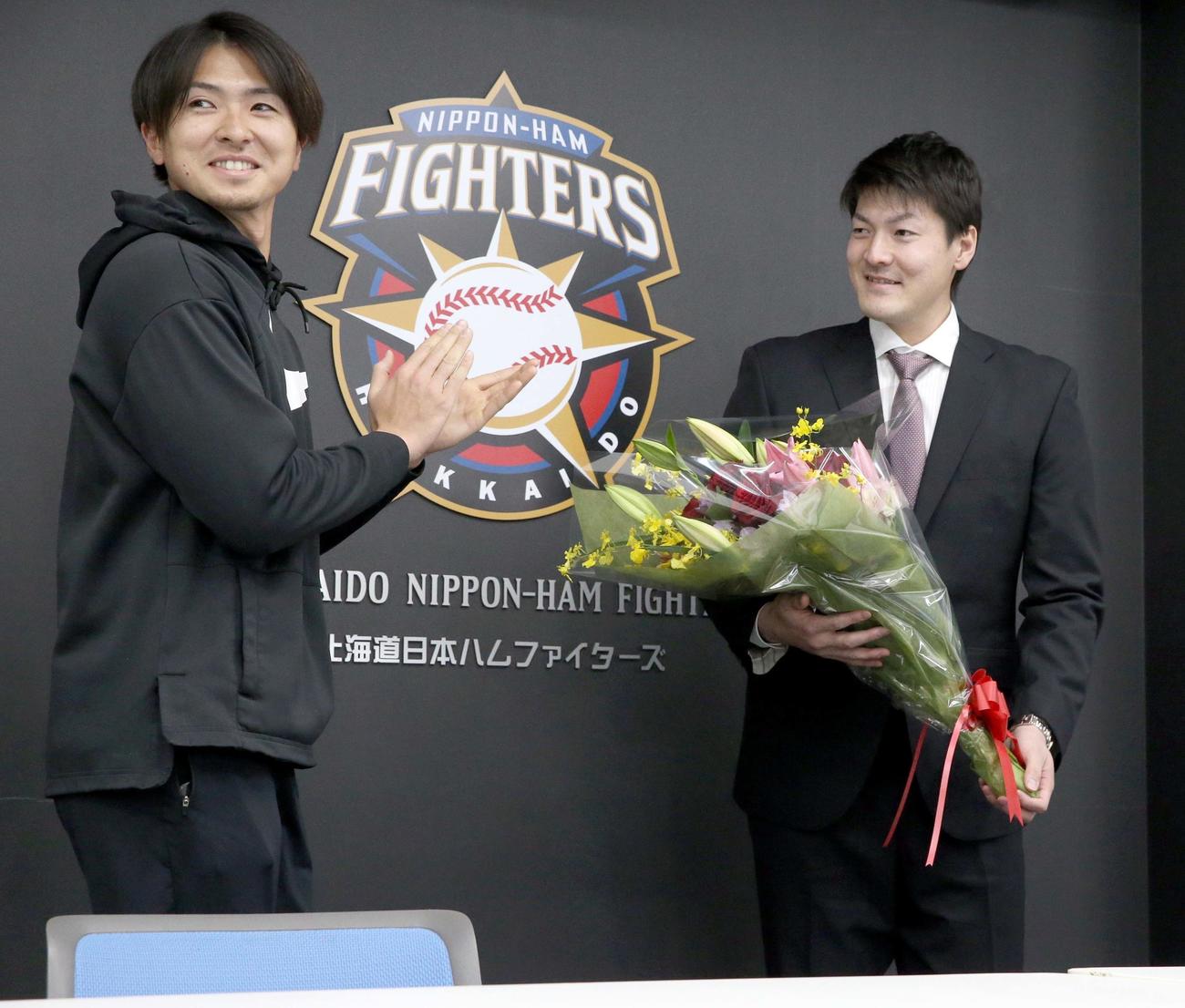 レンジャーズへの移籍が決まり退団会見に出席し日本ハム上沢（左）から花束を手渡され笑顔の有原（撮影・佐藤翔太）