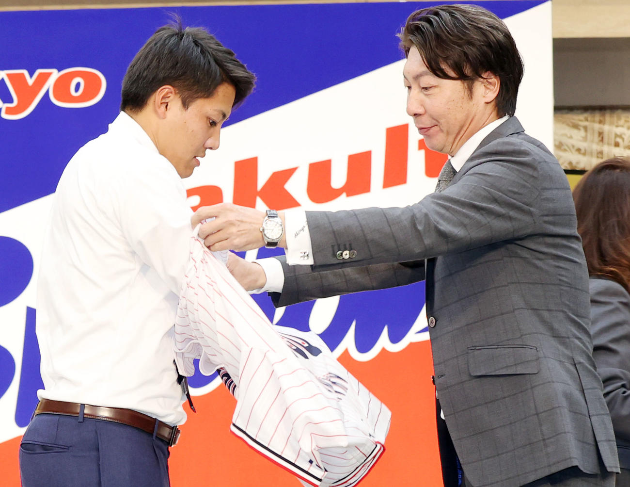 ヤクルト新入団発表会見で高津臣吾監督（右）からユニホームを着せてもらう育成2位の信濃GS・赤羽由紘（2020年12月1日撮影）