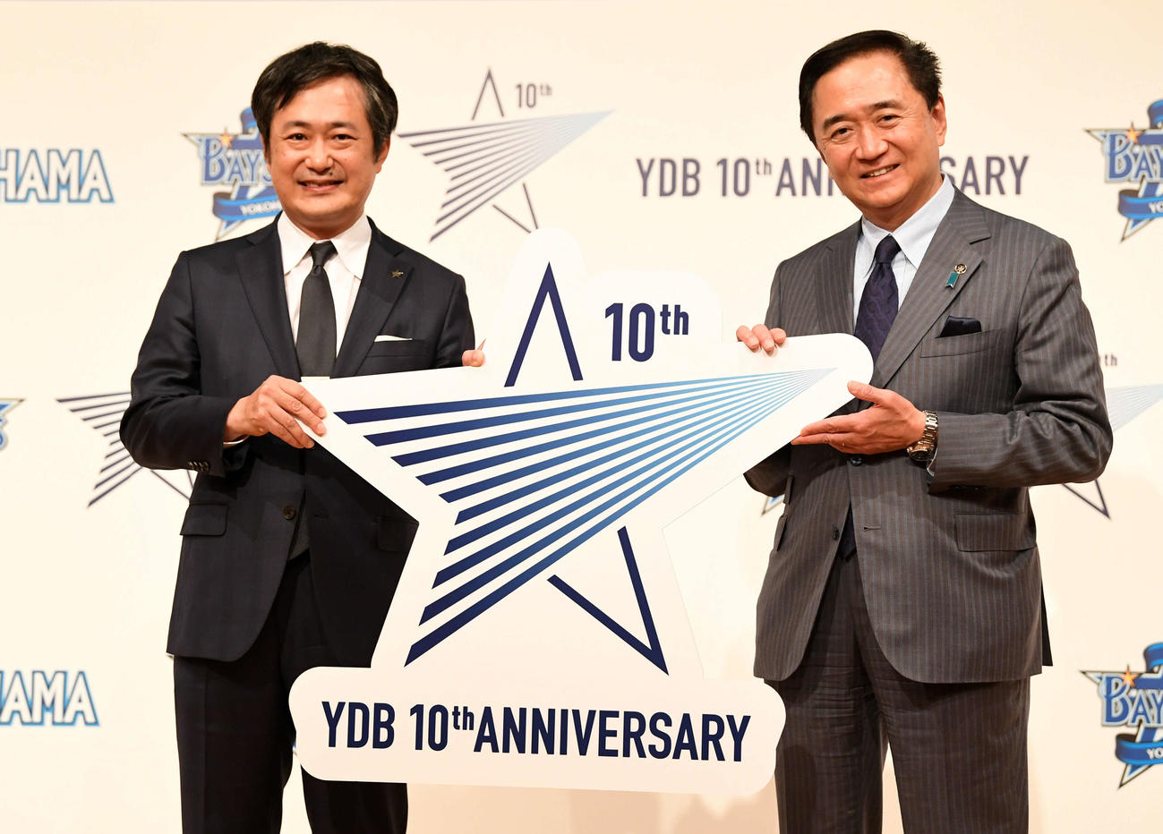 10周年ロゴを手に笑顔を見せるDeNA岡村球団社長（左）と神奈川県の黒岩知事（撮影・横山健太）