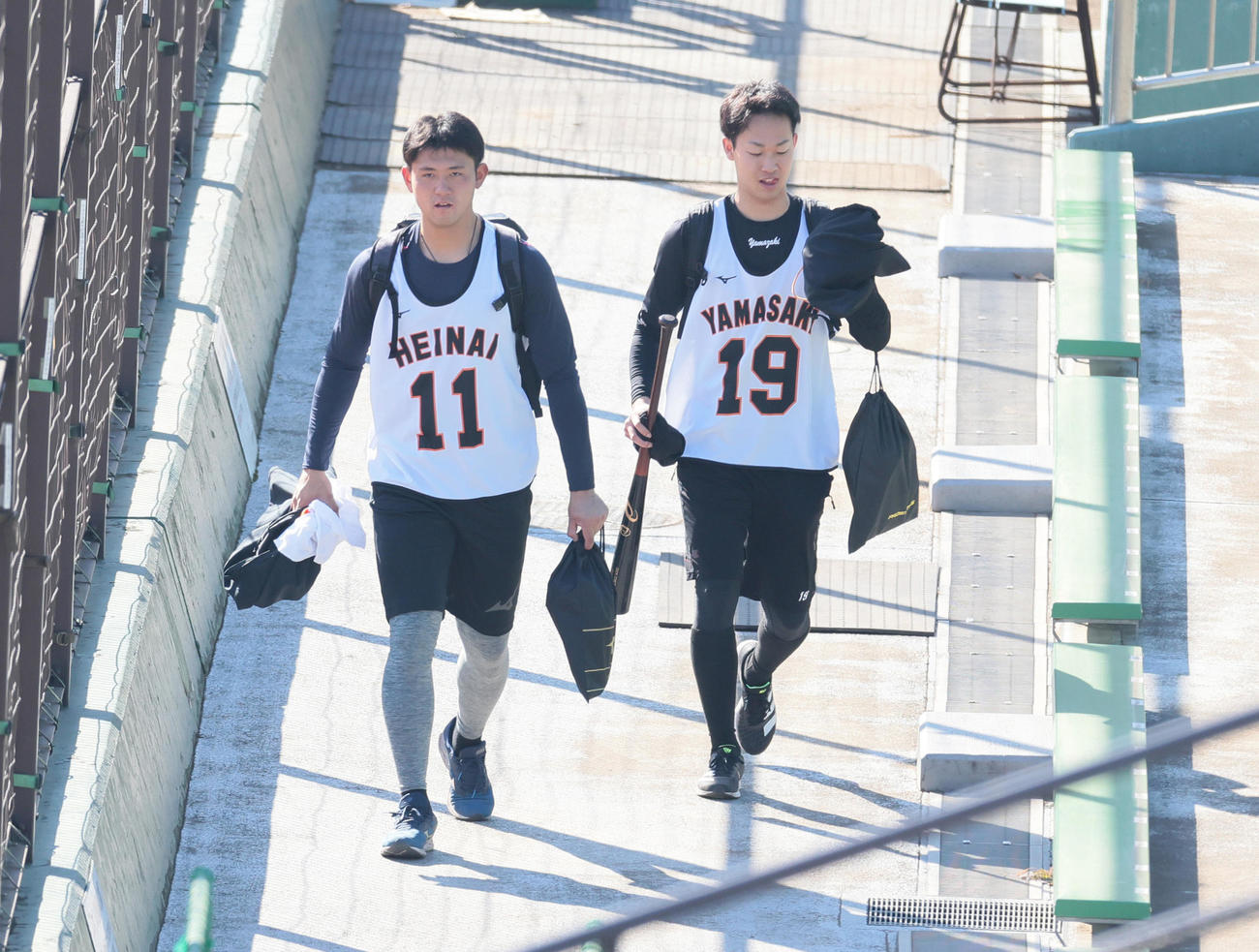 新人合同自主トレ中、スタンドを通り移動する巨人の平内（左）と山崎（撮影・足立雅史）