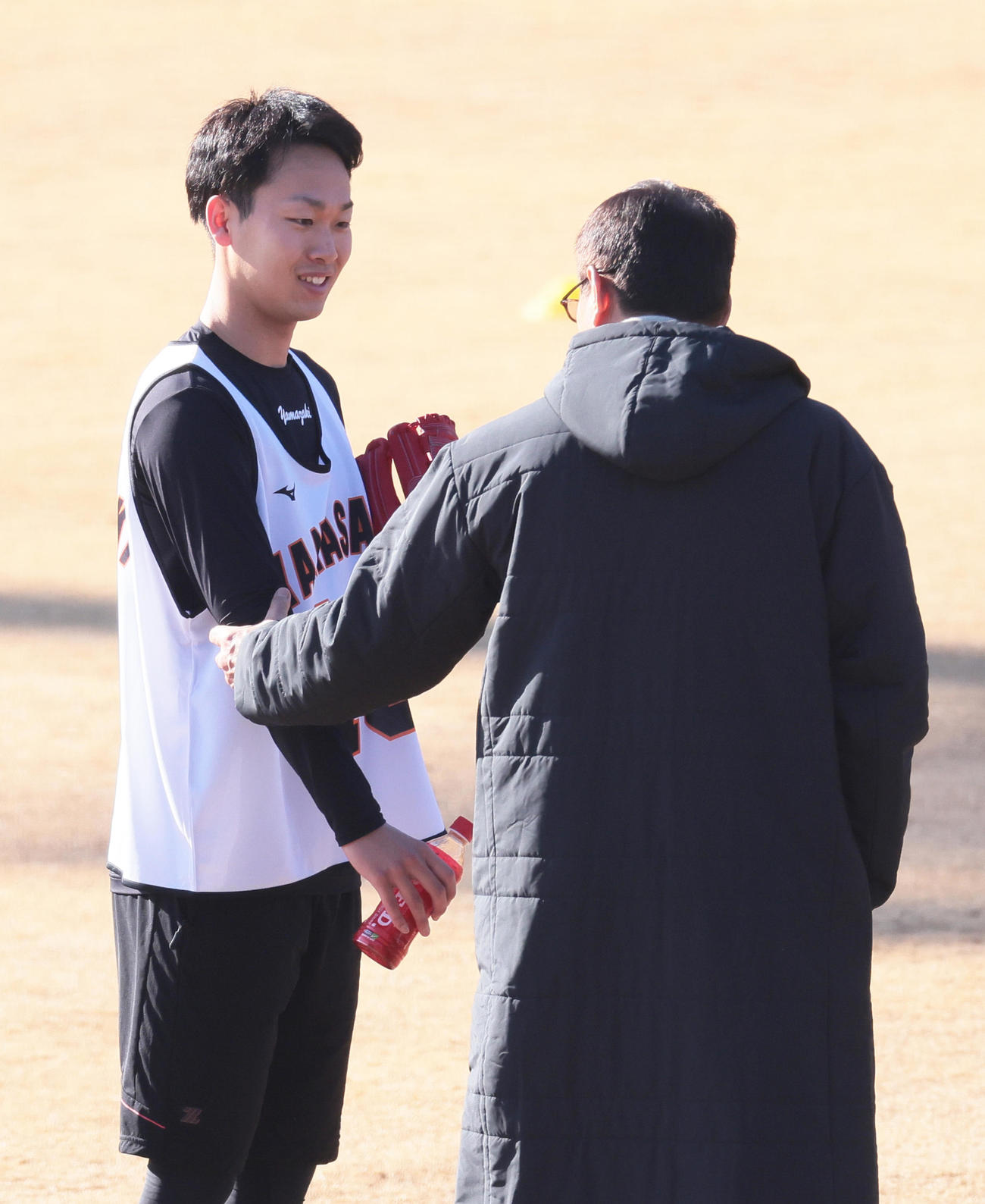 新人合同自主トレ中、巨人原監督（右）から声をかけられる山崎（撮影・足立雅史）