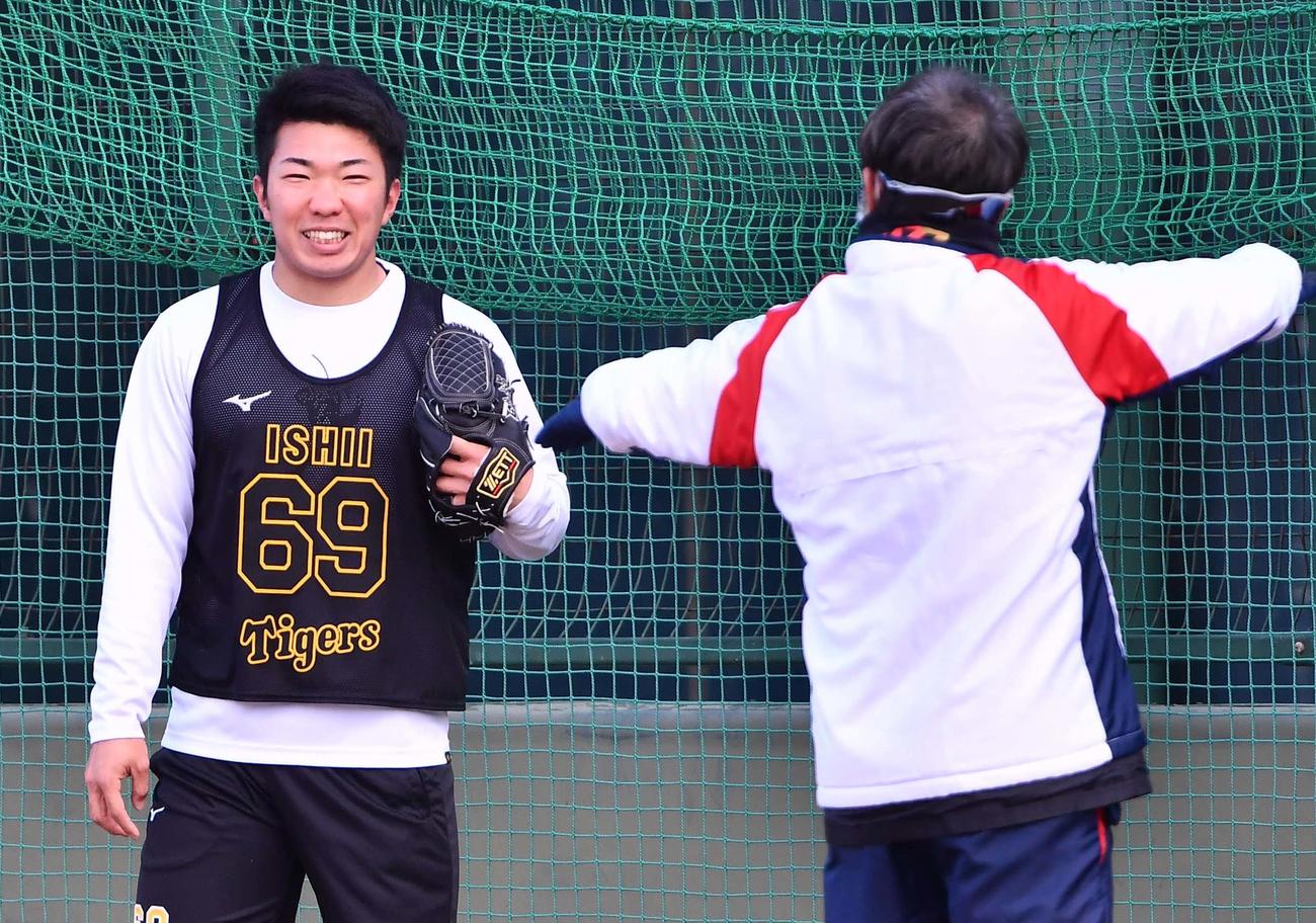 ブルペンでの投球練習を終えた石井大（左）は平田2軍監督に声を掛けられ笑顔を見せる（代表撮影）
