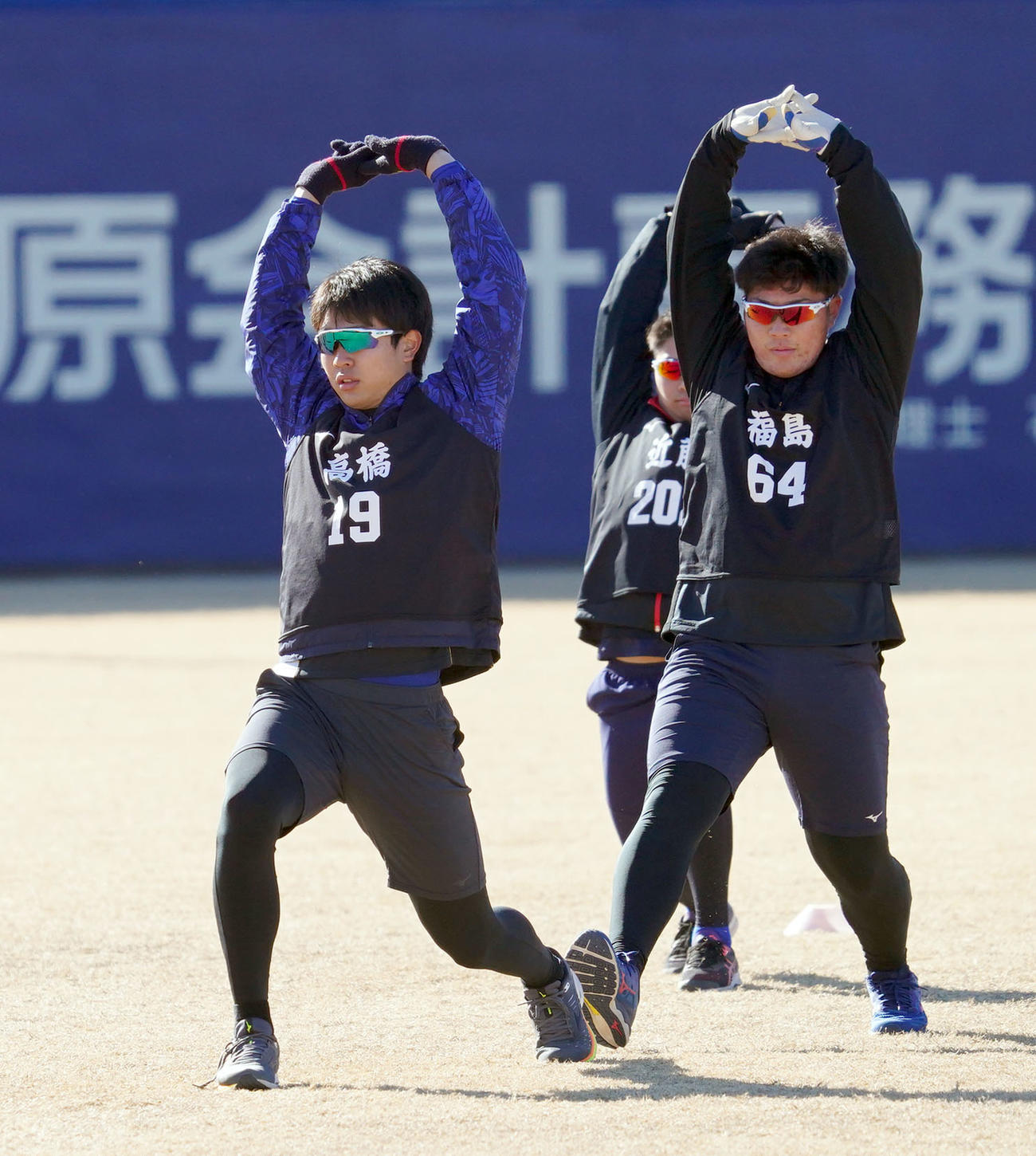 ストレッチで体をほぐす高橋宏斗（左）と福島章太（右）（撮影・森本幸一）