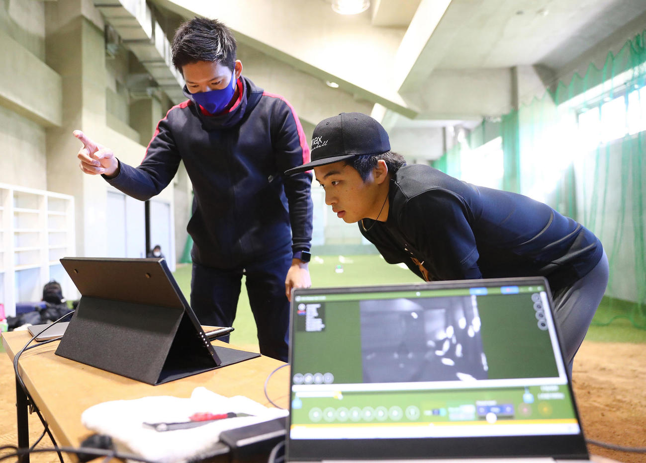 撮影したデータを見てネクストベースの森本氏（左）のアドバイスを受ける中日山本（代表撮影）
