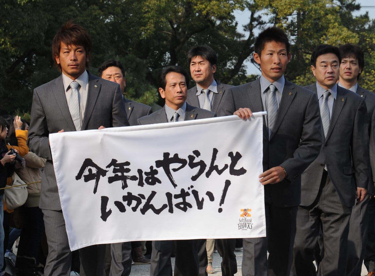 10年スローガン「今年はやらんといかんばい！」が入った幕を持ち、筥崎宮へ必勝祈願に訪れた松田、本多ら