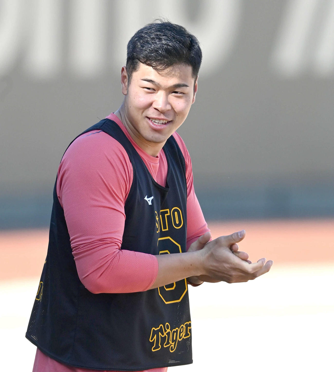 練習中、明るい表情で笑顔で手をたたく佐藤輝（代表撮影）