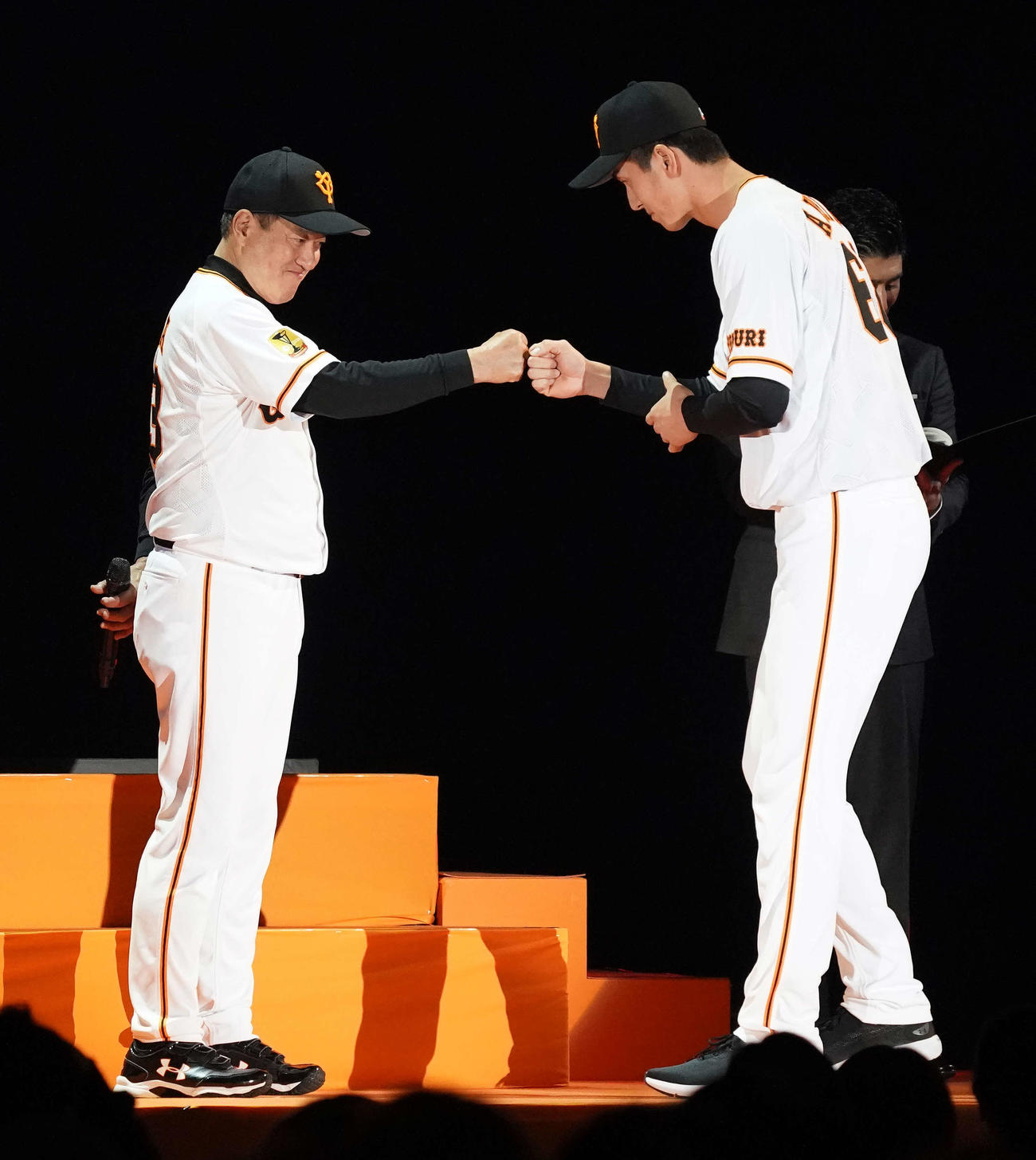 20年12月、新入団選手発表でタッチをかわす原辰徳監督（左）とドラフト5位の秋広