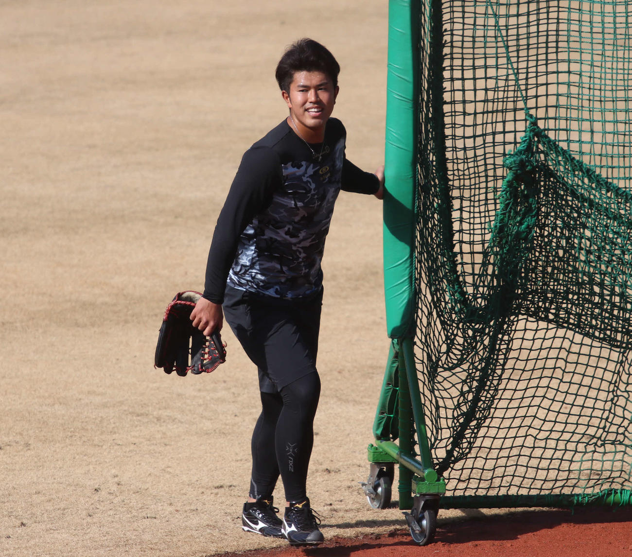 守備練習を終え、防球ネットを片付ける日本ハム今川（撮影・山崎純一）