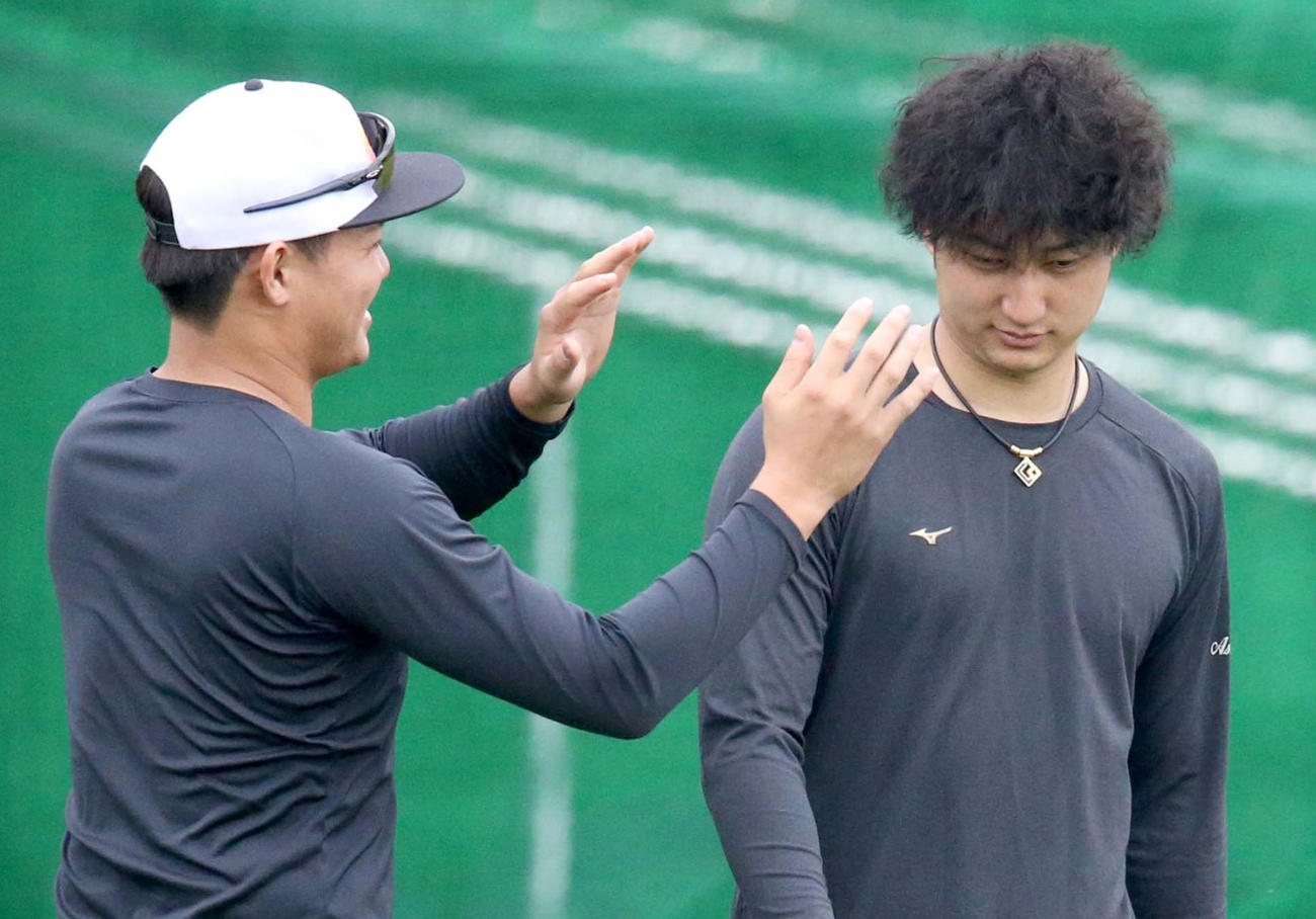 ツイストスパイラルパーマにした日本ハム浅間（右）の髪形に興味を示す郡（撮影・佐藤翔太）