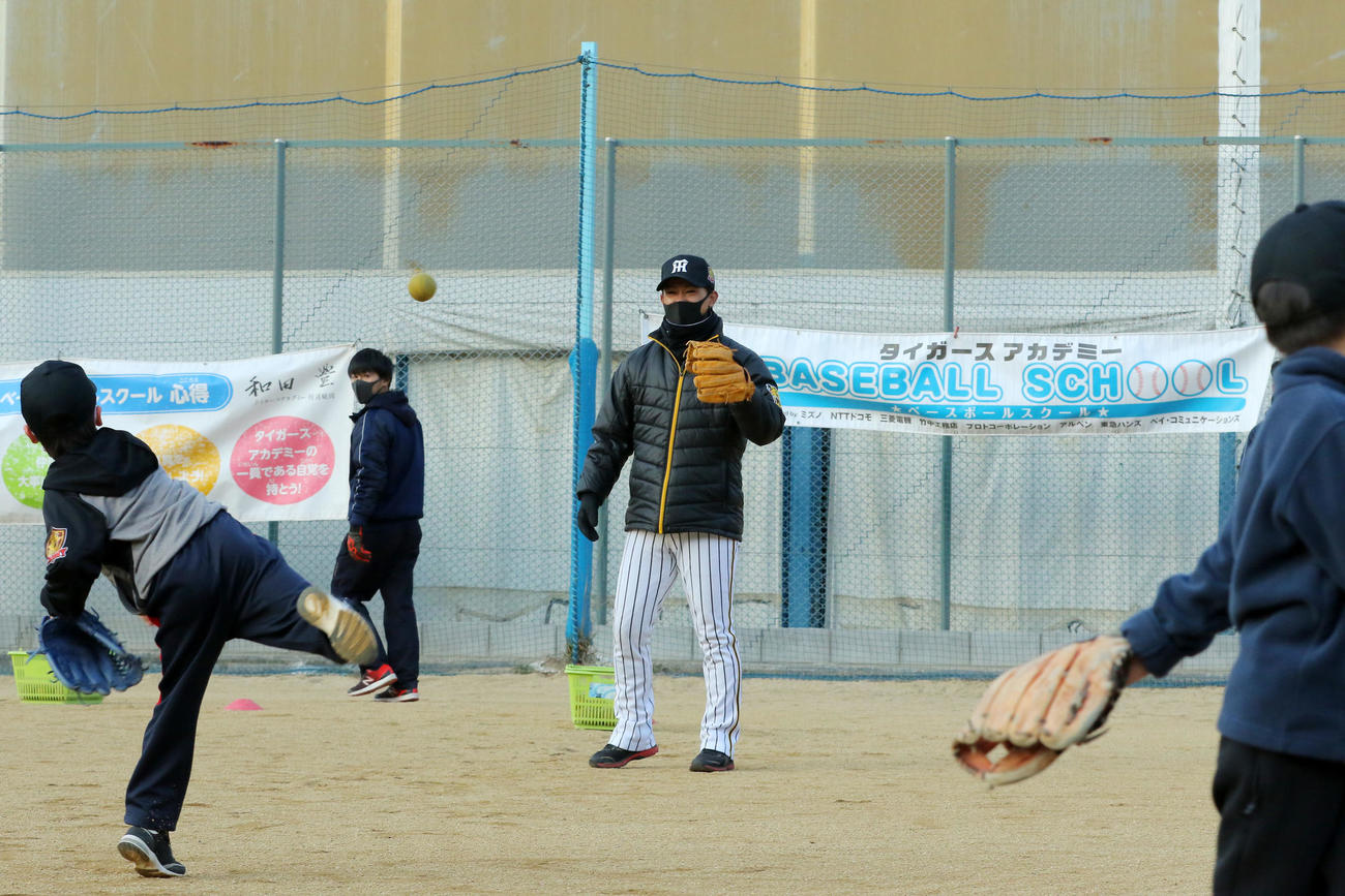 タイガースアカデミーで子どもたちとキャッチボールする上本博紀コーチ（球団提供）