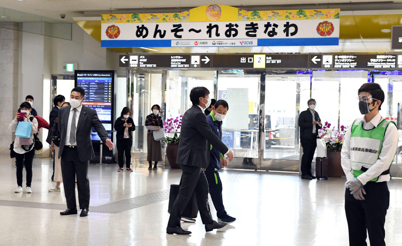 那覇空港の到着口に姿を見せる高津監督（中央）。例年と異なり閑散としていた（撮影・山崎安昭）