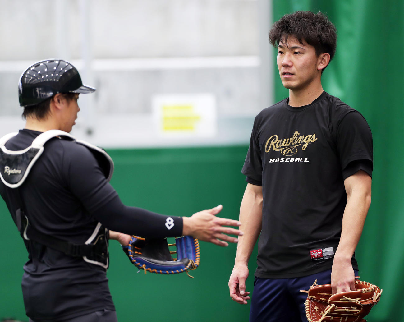 ブルペンでの投球を終え、梅野（左）のアドバイスを聞く伊藤将司（撮影・前田充）