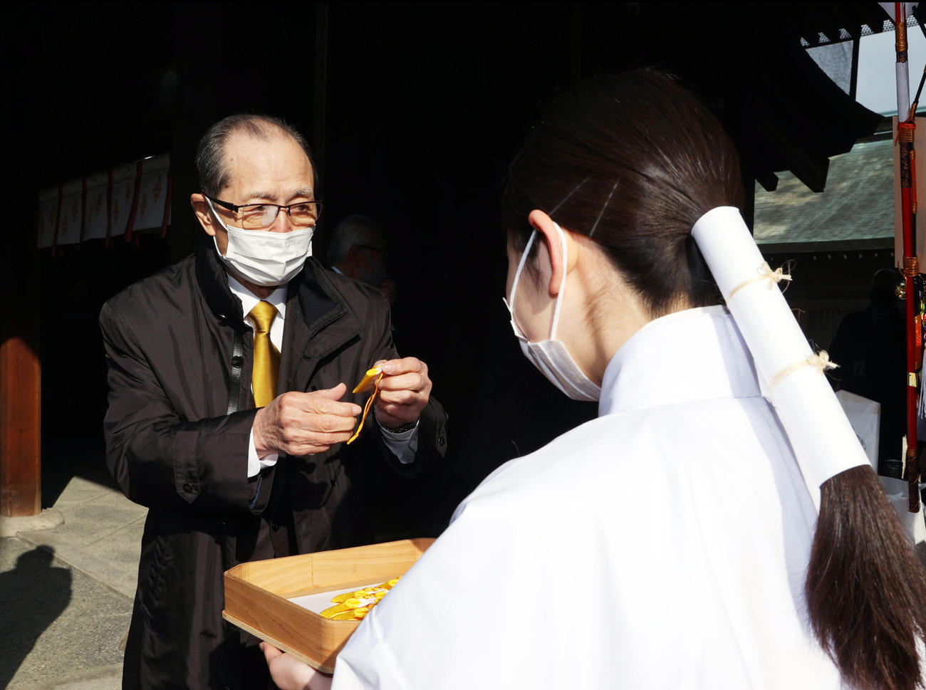 お守りを受け取る王会長（代表撮影）