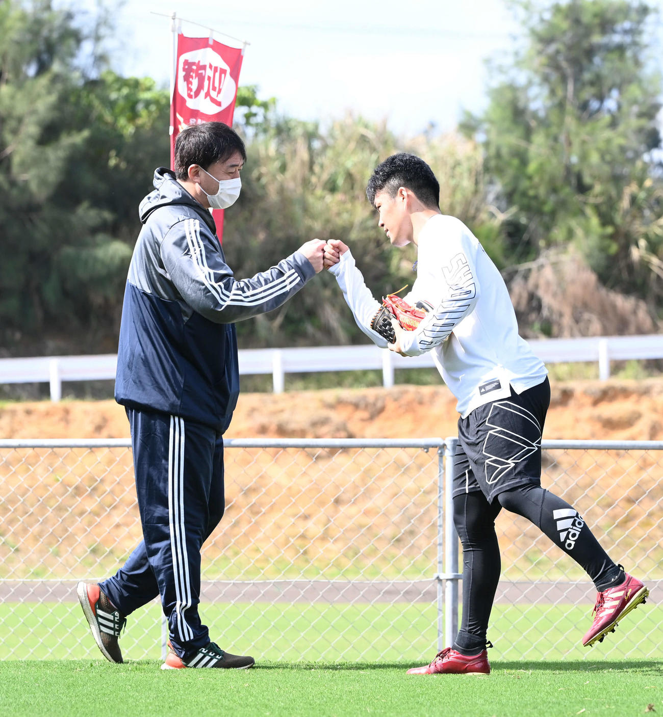 楽天石井GM兼監督（左）はブルペン投球をしていた則本昂とグータッチ（撮影・山崎安昭）