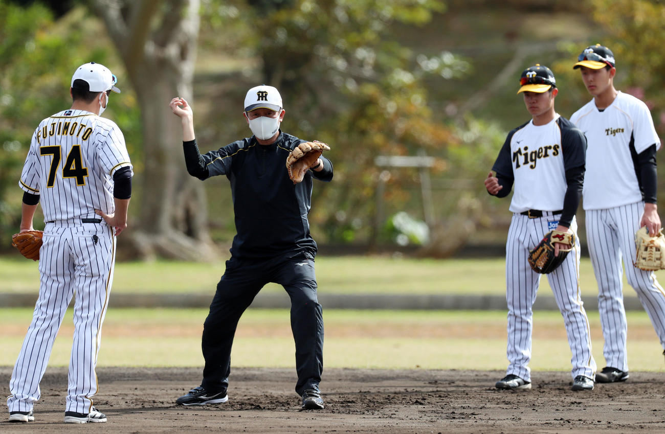 サブグラウンドで守備練習する小幡（右端）と中野にアドバイスを送る川相臨時コーチ、左端は藤本コーチ（撮影・加藤哉）