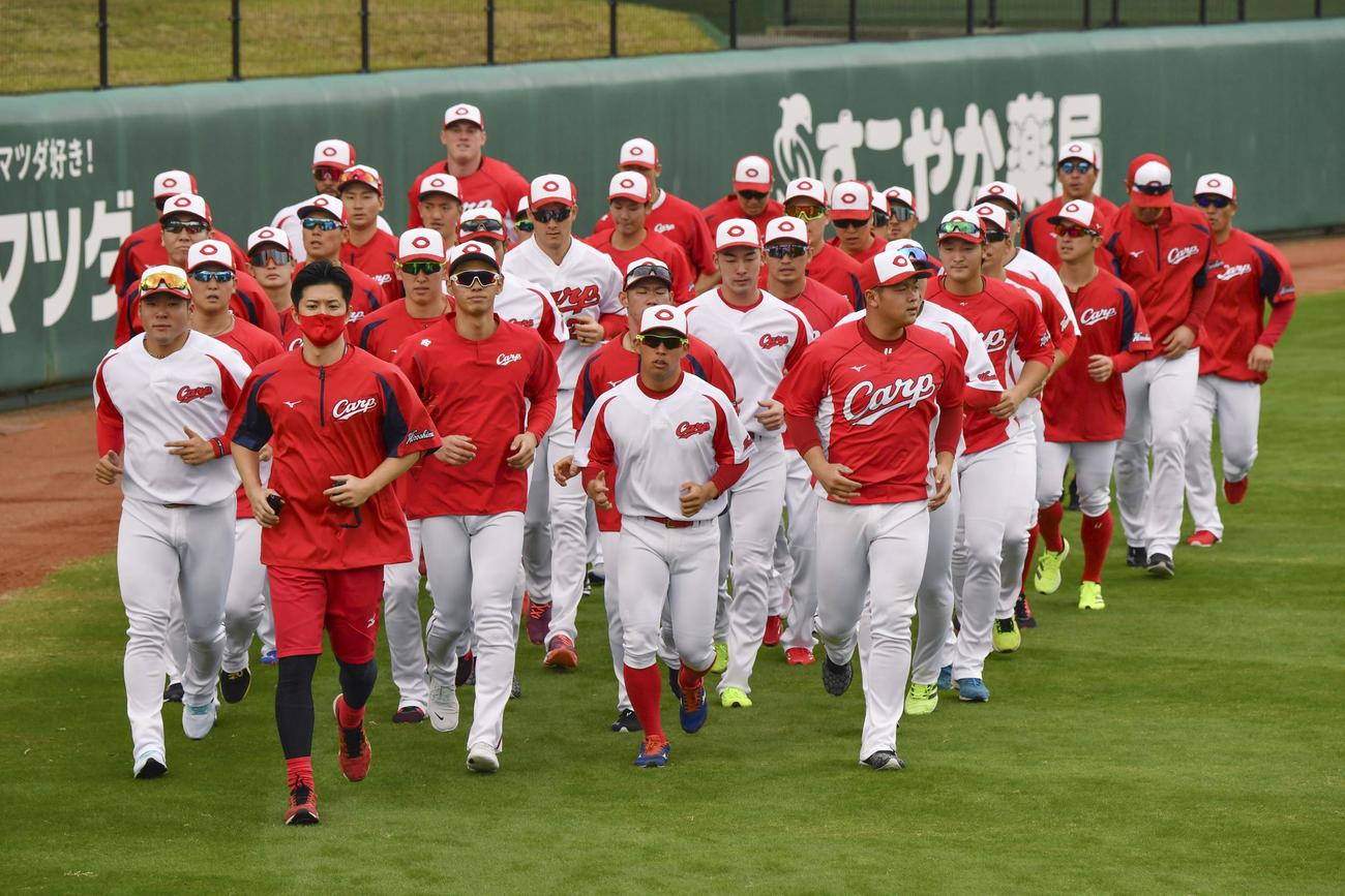 キャンプ初日を迎え、ランニングする広島ナイン（共同）