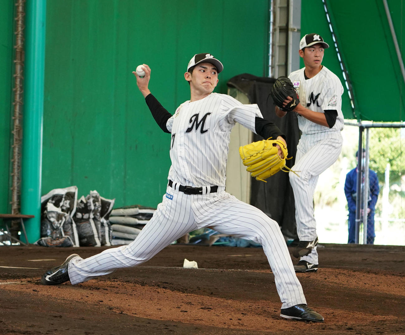ブルペンで力投するロッテ佐々木朗。右は古谷