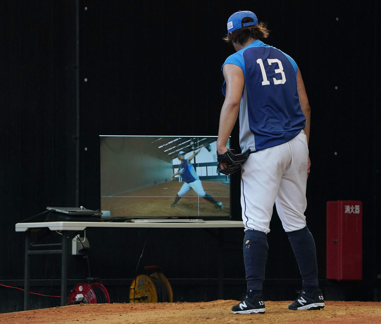 ブルペンの個別練習でモニターに映る自身の投球フォームを確認する西武高橋（撮影・滝沢徹郎）