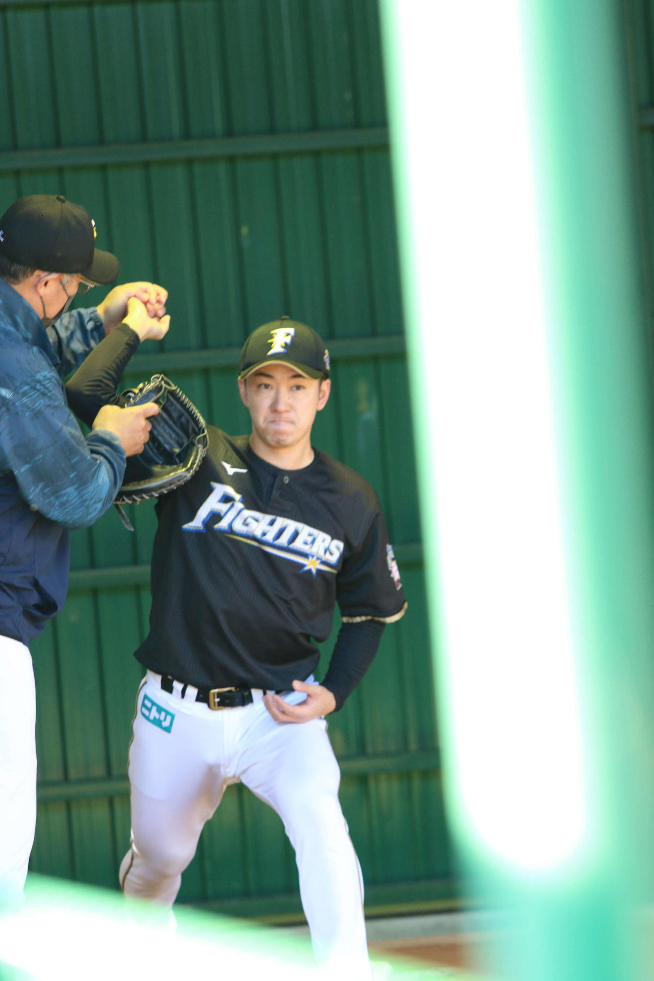 ブルペンで木田2軍総合兼投手コーチと右肘を確認する日本ハム斎藤（撮影・田中彩友美）