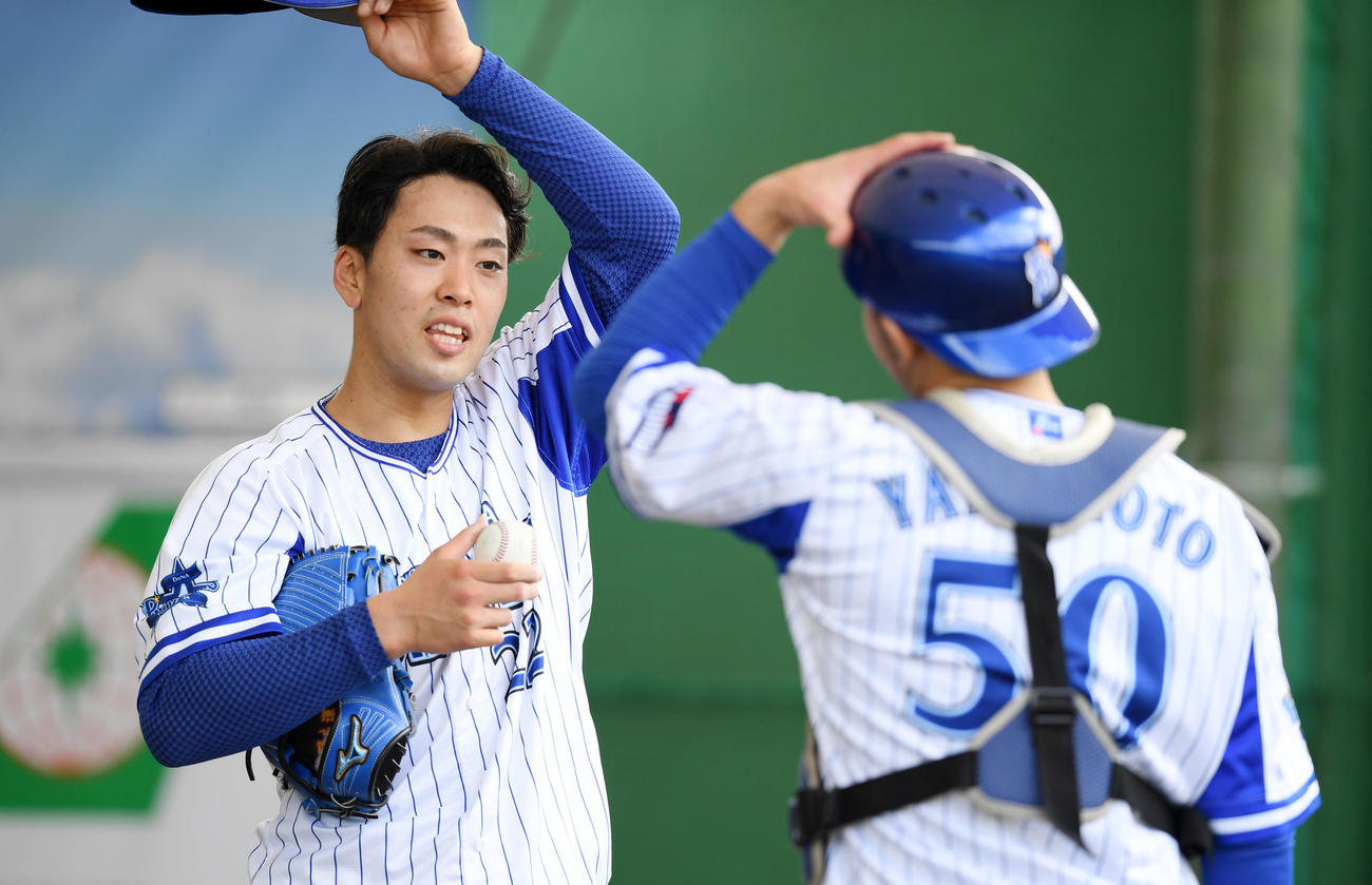 ブルペンでの投球練習後、DeNA山本（右）と会話を交わす入江（撮影・横山健太）