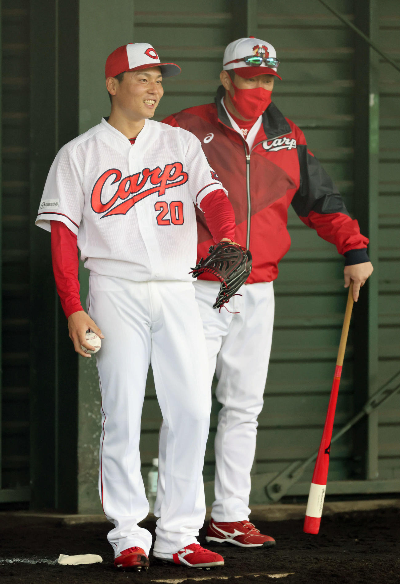 ブルペンで佐々岡監督（右）と話すドラフト1位の栗林（撮影・加藤孝規）