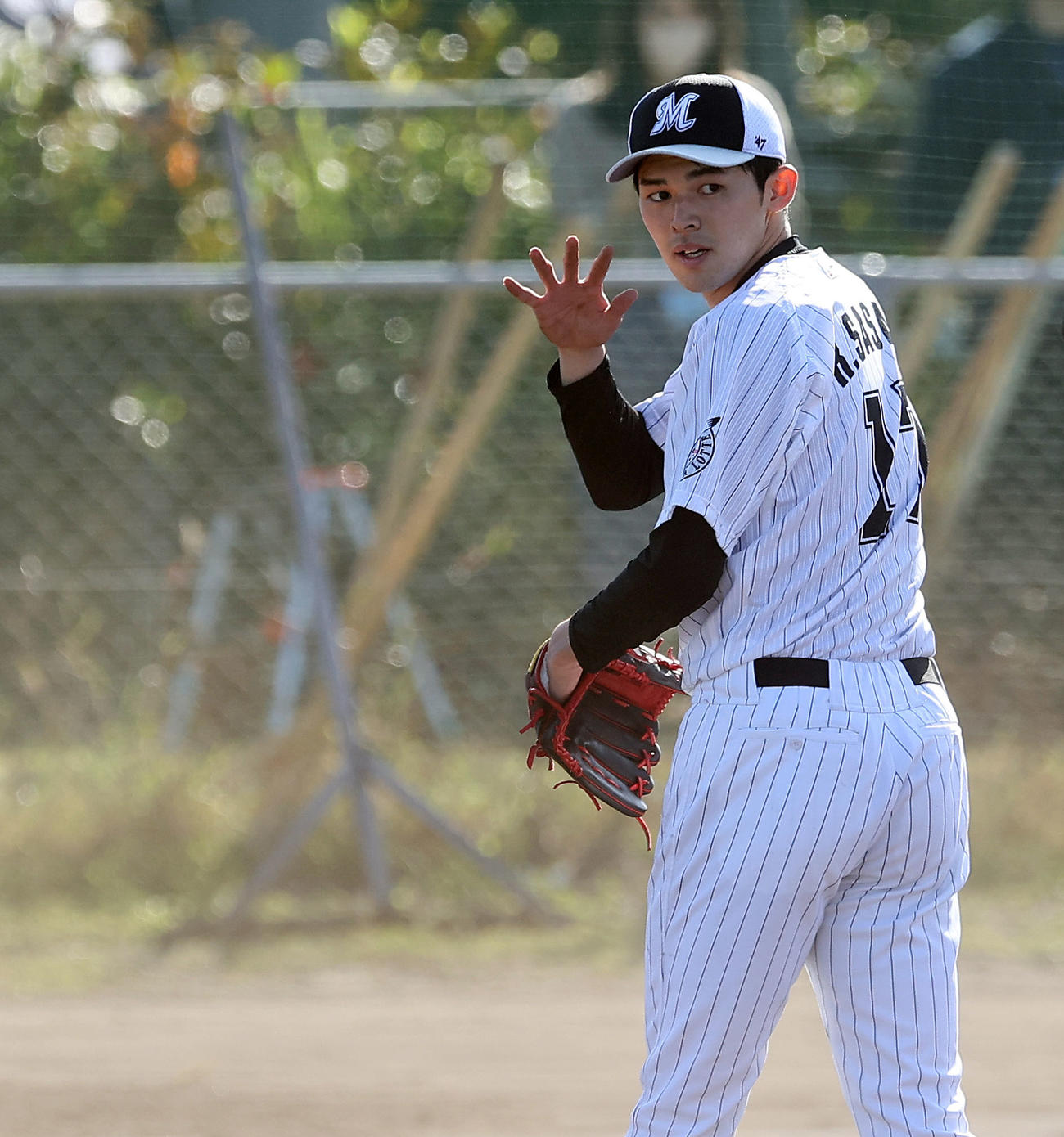 投内連係で合図を送るロッテ佐々木朗希（撮影・垰建太）