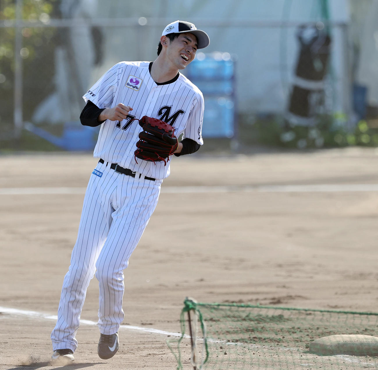 投内連係で笑顔を見せるロッテ佐々木朗希（撮影・垰建太）
