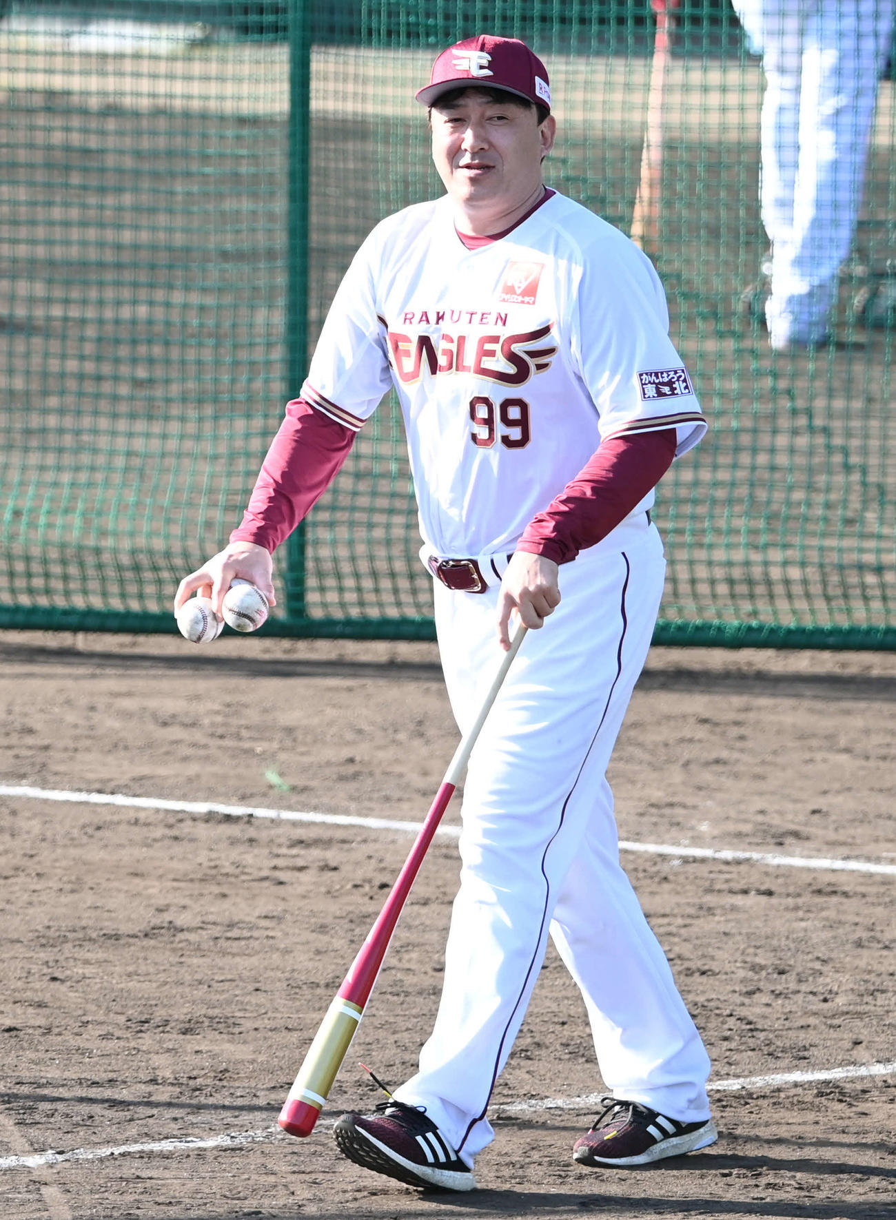 打撃練習の球拾いをする楽天石井GM兼監督（撮影・山崎安昭）