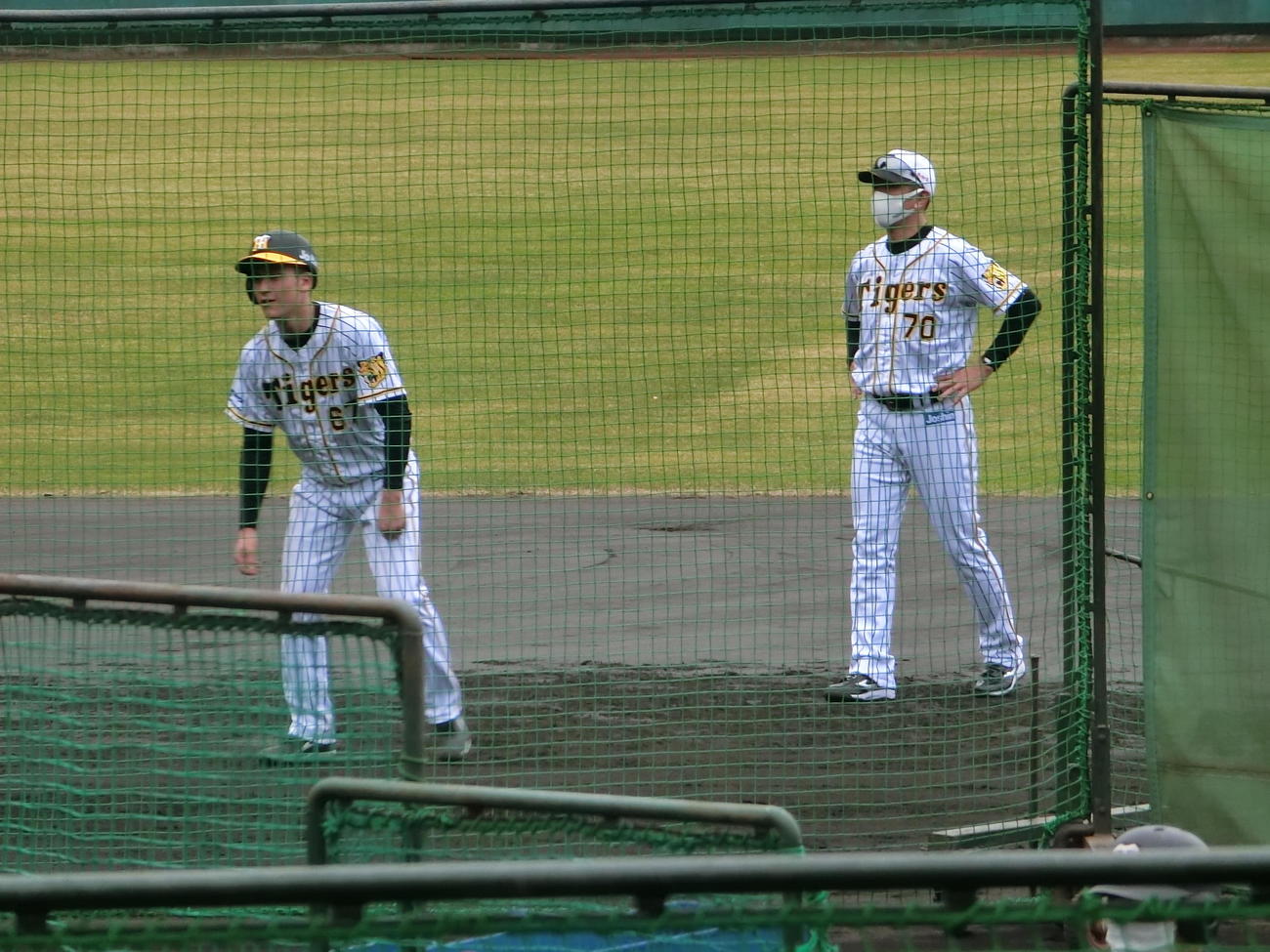 田中内野守備走塁コーチ（右）から走塁指導を受けるドラフト7位高寺（撮影・奥田隼人）