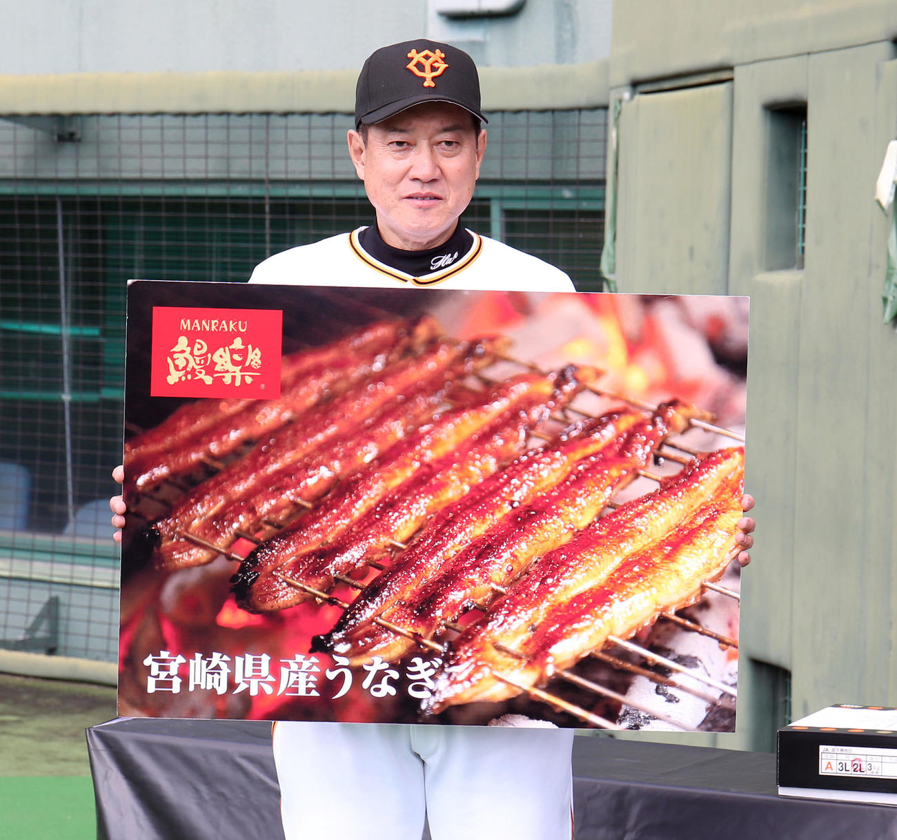 宮崎県の特産のうなぎもボードでもらう原監督（撮影・狩俣裕三）