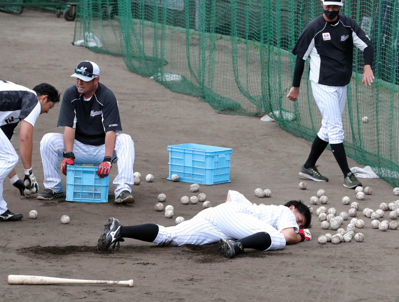 松中臨時コーチ（左）の居残り連続トス打撃を終えボールの海に倒れ込むロッテ安田（撮影・垰建太）