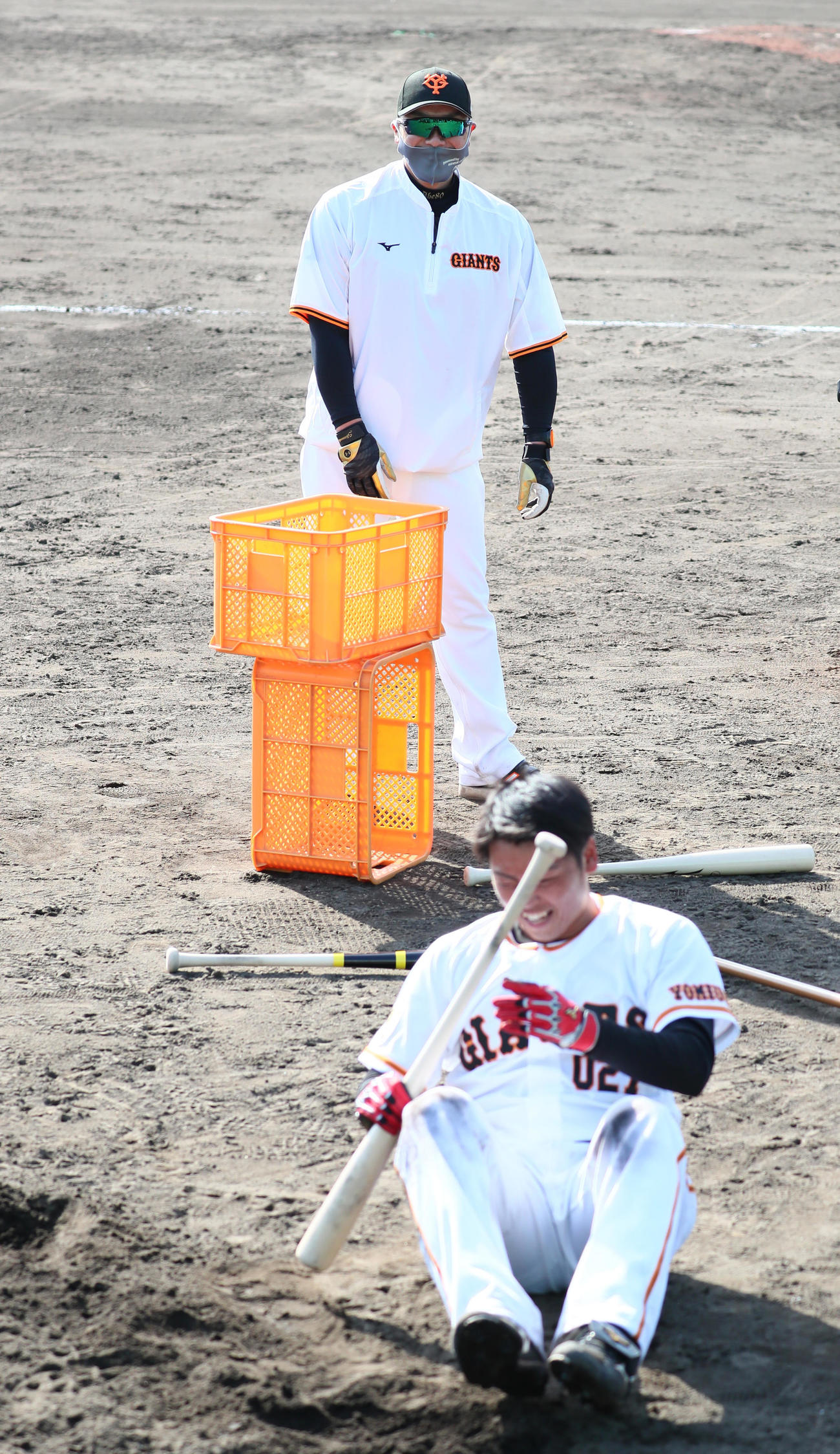 厳しい練習に思わず倒れ込んだ巨人喜多（手前）を笑顔で見つめる阿部2軍監督（撮影・足立雅史）