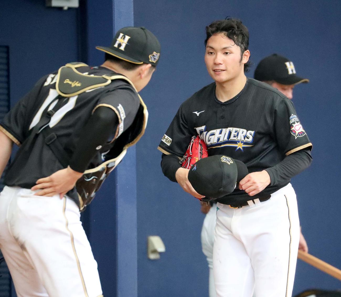 ブルペンでの投球を終えた日本ハム伊藤は清水と言葉を交わす（撮影・佐藤翔太）