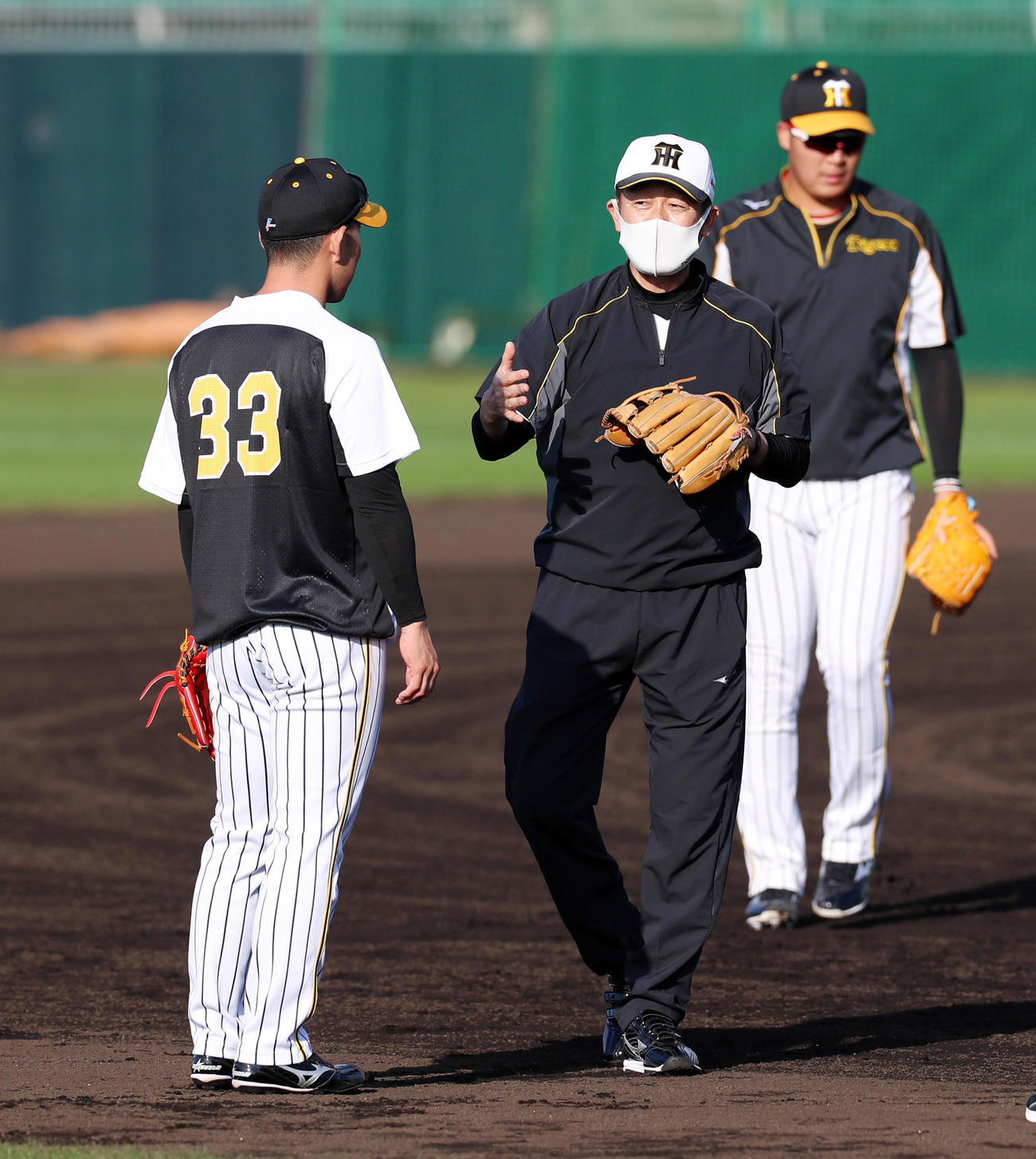 早出特守の糸原健斗（左）にアドバイスする川相昌弘臨時コーチ（撮影・加藤哉）