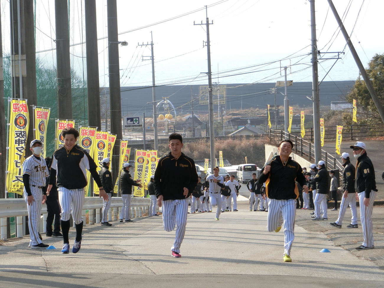 安芸漁港をバックに坂道ダッシュを行う、左から阪神遠藤、高寺、藤田（撮影・奥田隼人）