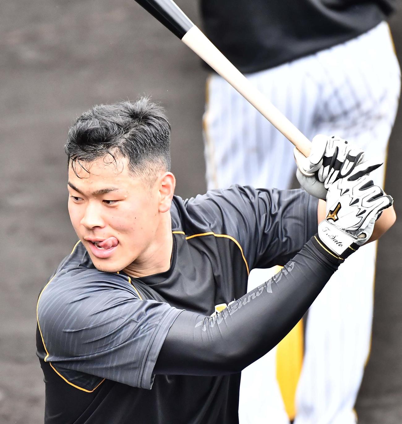 舌を出しながら打撃練習をする佐藤輝（撮影・上田博志）