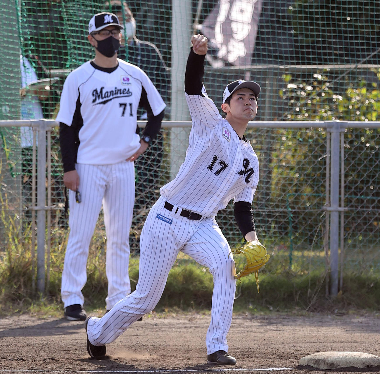 吉井投手コーチ（左）が見つめる中、キャッチボールするロッテ佐々木朗（撮影・垰建太）