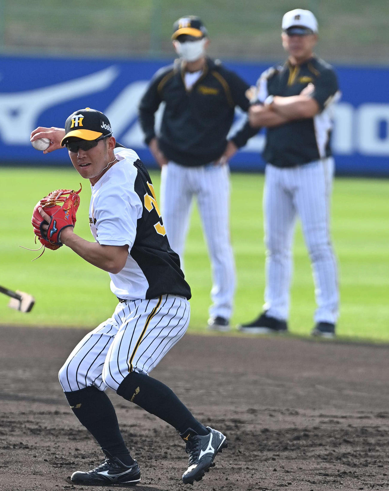 井上一樹打撃コーチ（右）矢野燿大監督が見守る中、早出特守する糸原健斗（撮影・上田博志）
