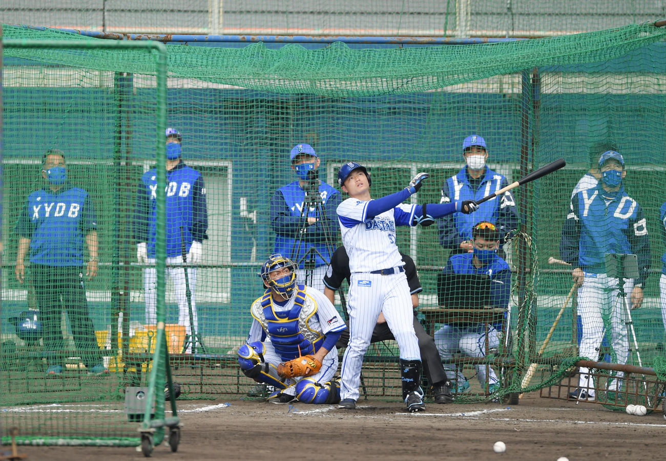 フリー打撃で快音を響かせるDeNA細川。打撃投手砂田（撮影・横山健太）