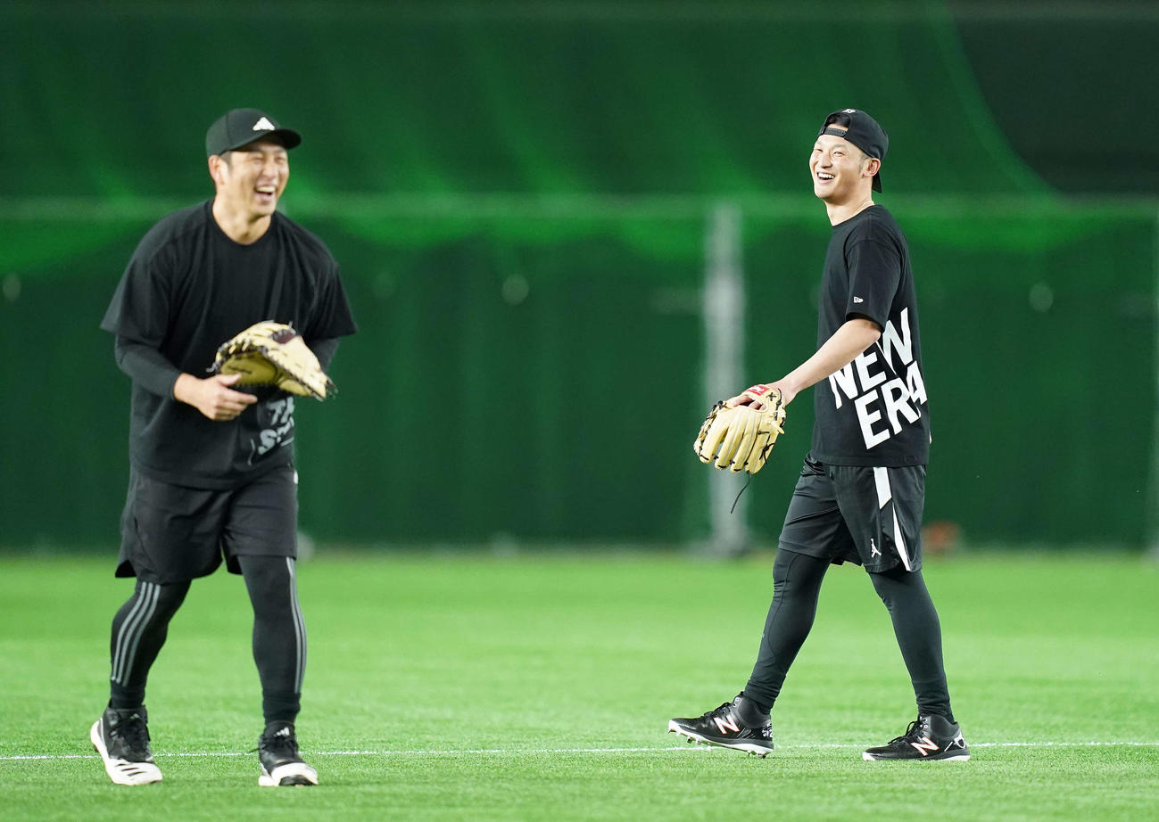 ノックの合間に笑顔を見せる巨人吉川。左は中島（撮影・鈴木みどり）