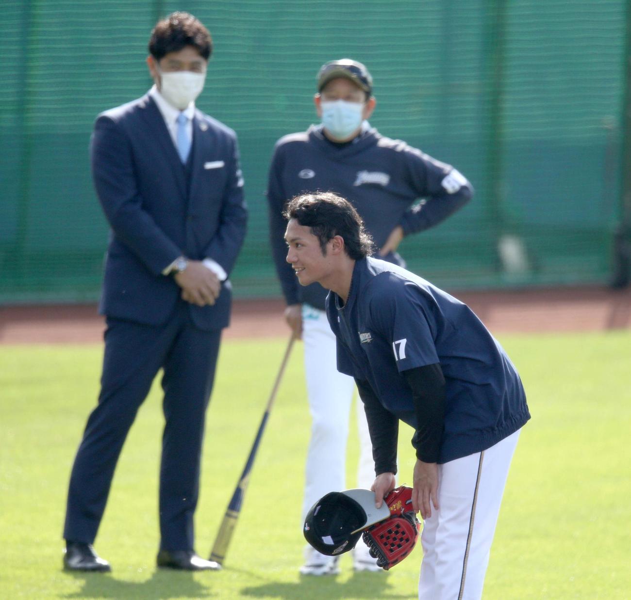 侍ジャパン稲葉監督（左奥）とあいさつを終え、侍ジャパン建山投手コーチにあいさつをする日本ハム伊藤。右奥は栗山監督（撮影・佐藤翔太）