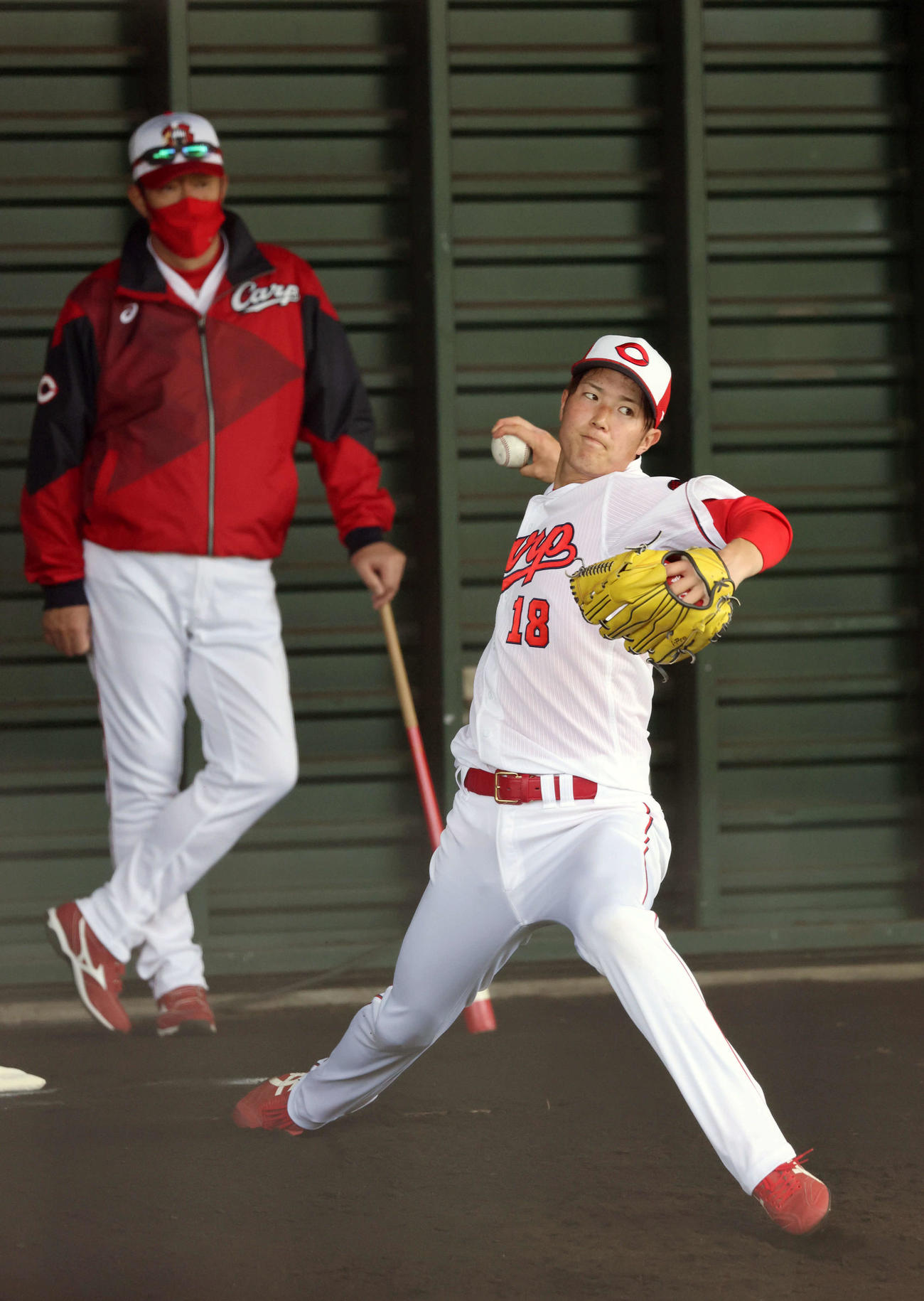 広島沖縄キャンプ　ブルペンで投げる森下。左は佐々岡監督（撮影・加藤孝規）