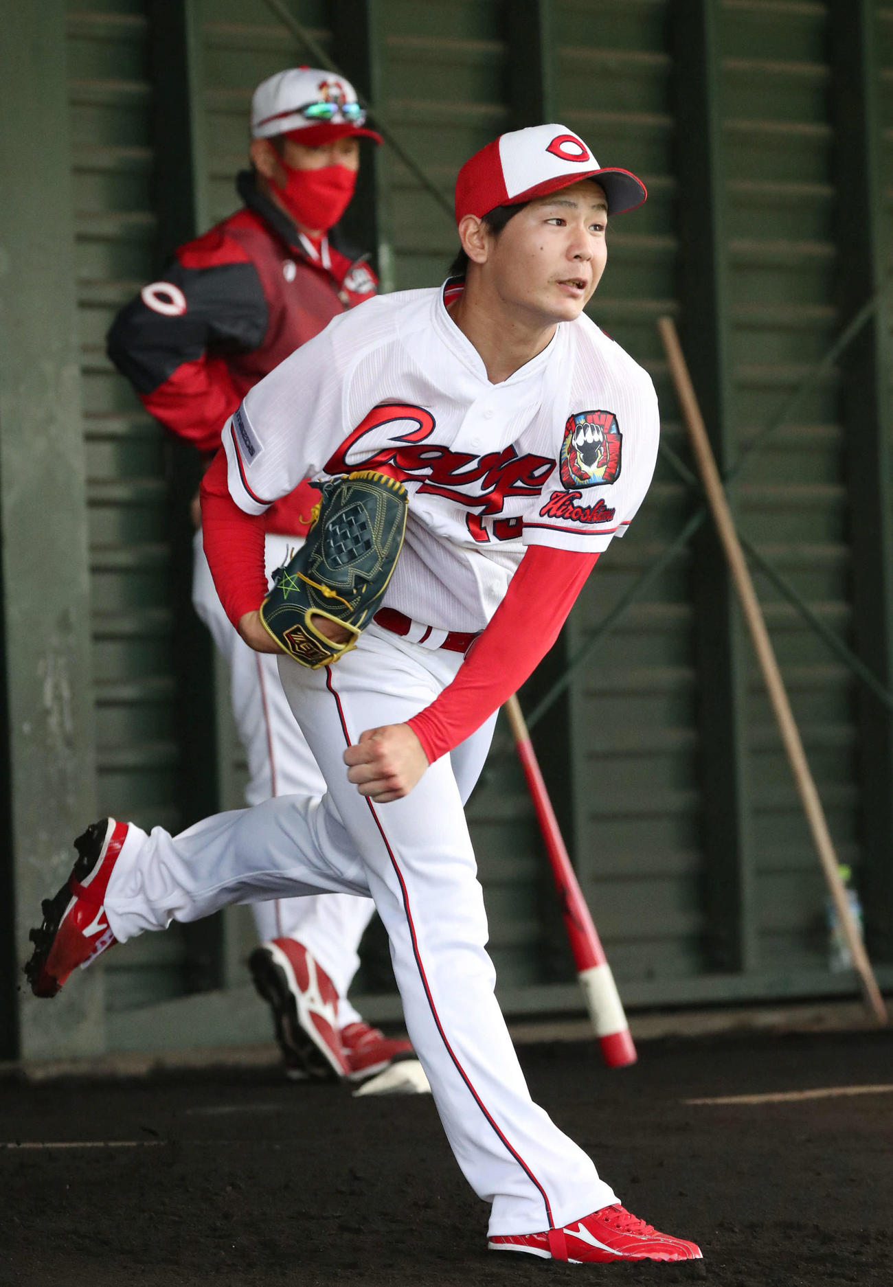 ブルペンで投げるドラフト2位の森浦。後ろは佐々岡監督