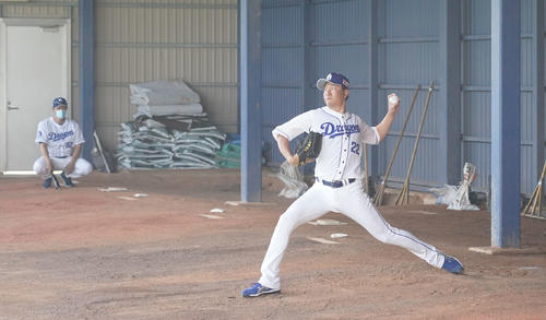 ブルペンで与田剛監督（左・奥）が見つめる前で投球練習を行った中日大野雄大。背番号と同じ22球を投げ込んだ（撮影・森本幸一）